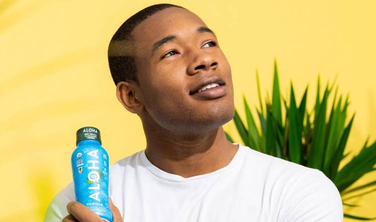 a man is holding a bottle of aloha vanilla tea a man is holding a bottle of aloha vanilla tea
